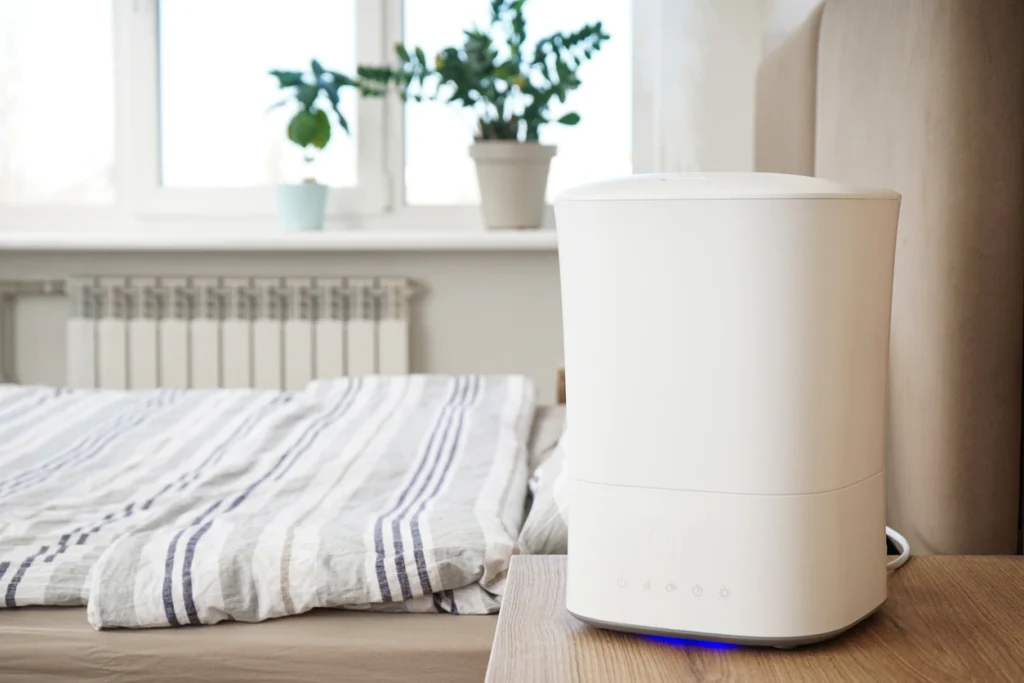 Whole-Home Humidifier In St. Louis Park, MN 1 A white air purifier placed on a neatly made bed, showcasing its sleek design and functionality in a bedroom setting.